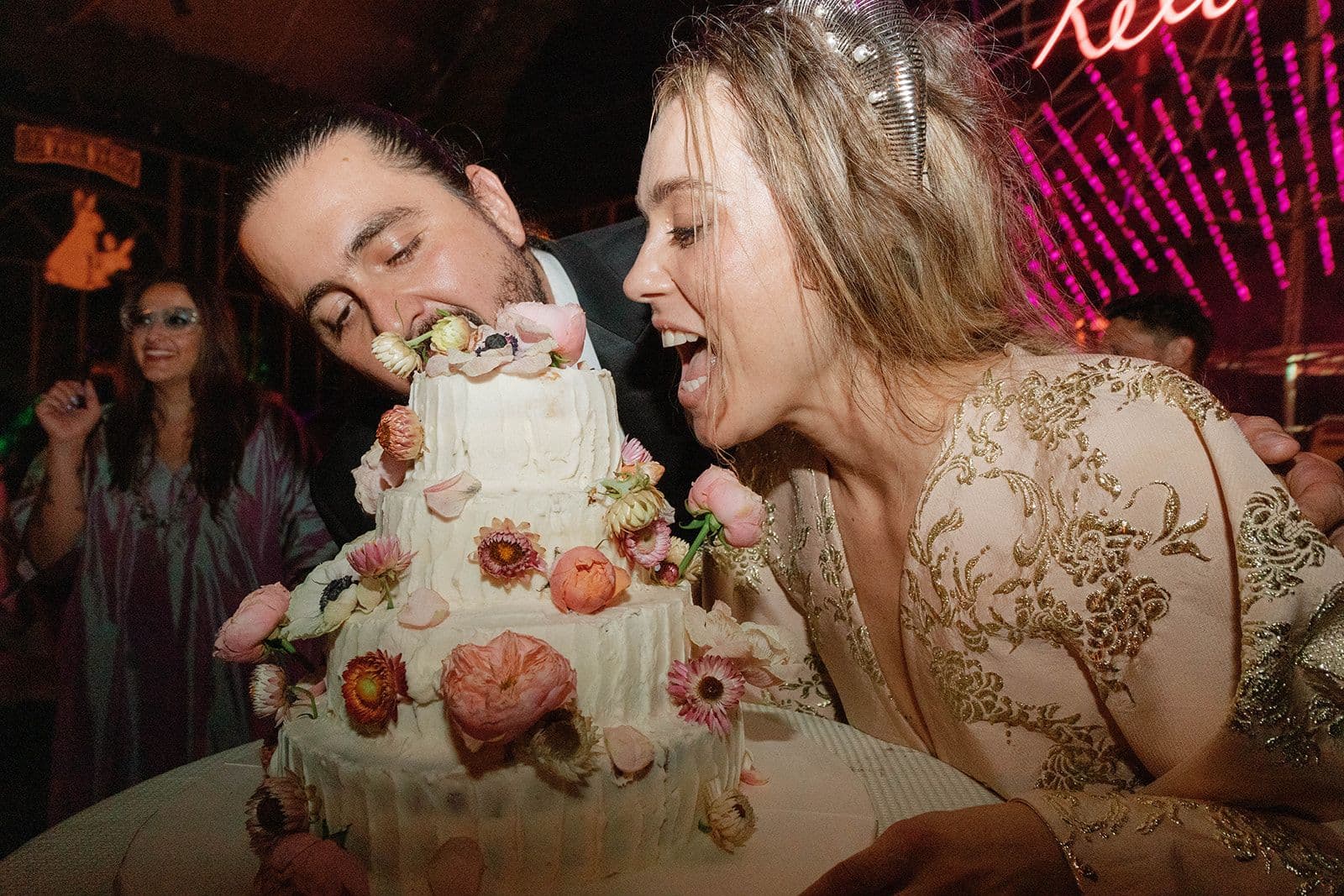 Amaury Lopez y Valeria Bross mordiendo su pastel de bodas