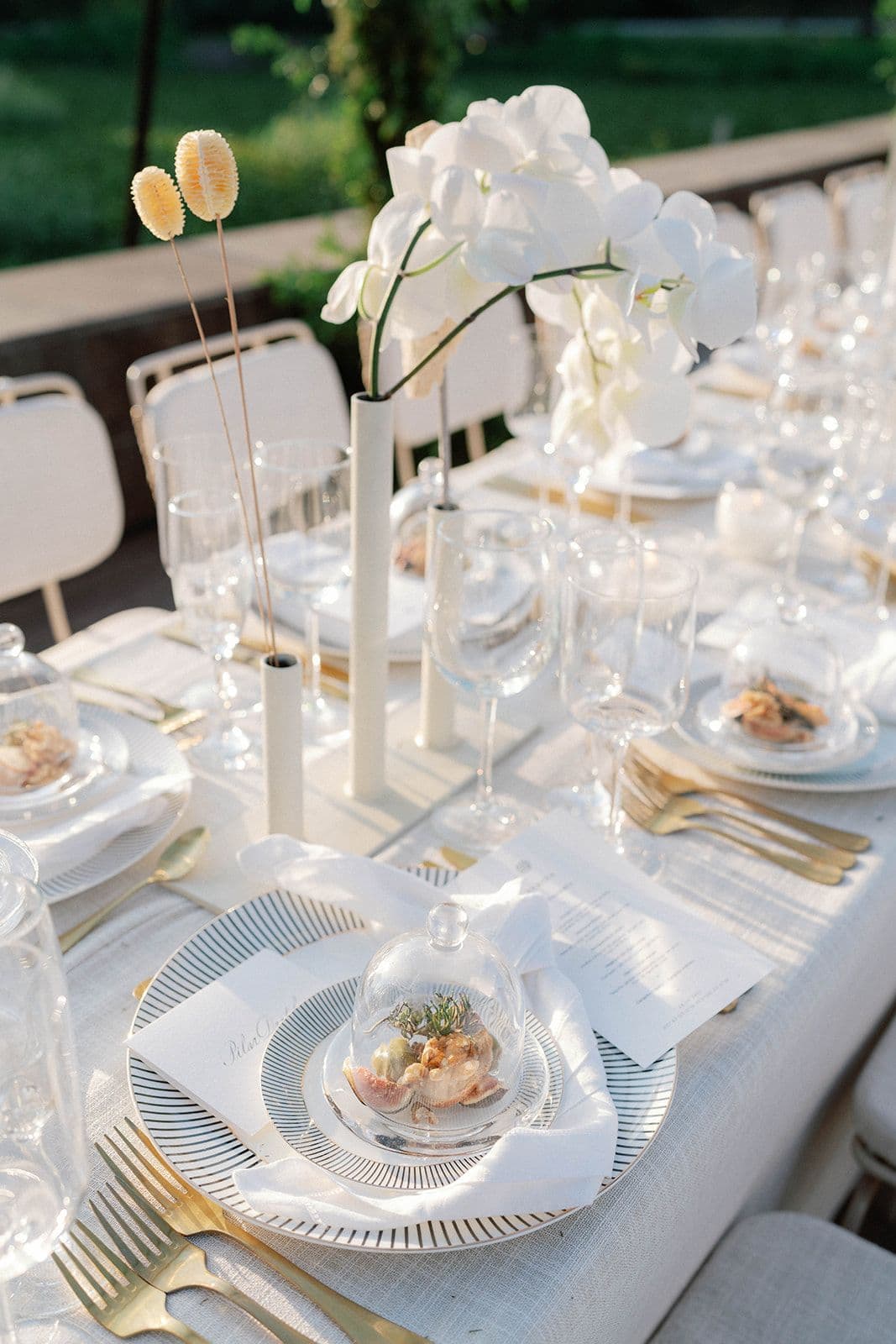 La mesa de bodas, con toda la vajilla puesta y un lago de fondo